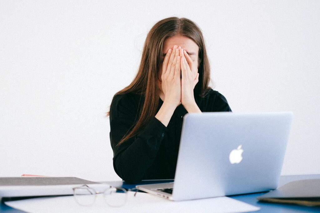 Common Challenges and Solutions: Woman stressed in front of her laptop